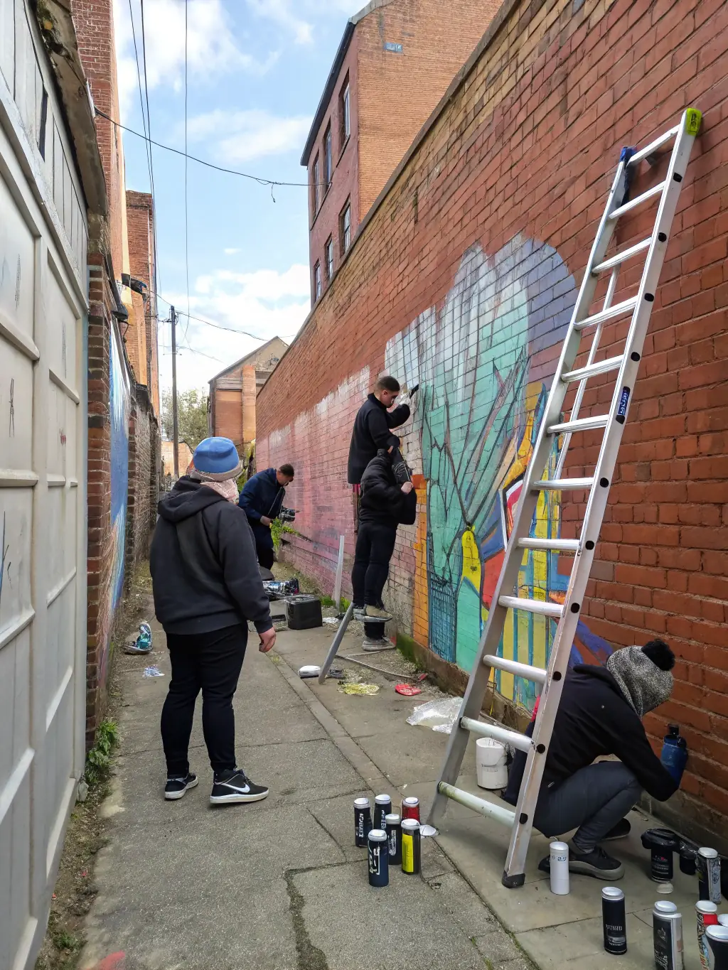 A vibrant image of a collaborative mural painting session, showcasing artists of diverse backgrounds working together on a large-scale artwork.